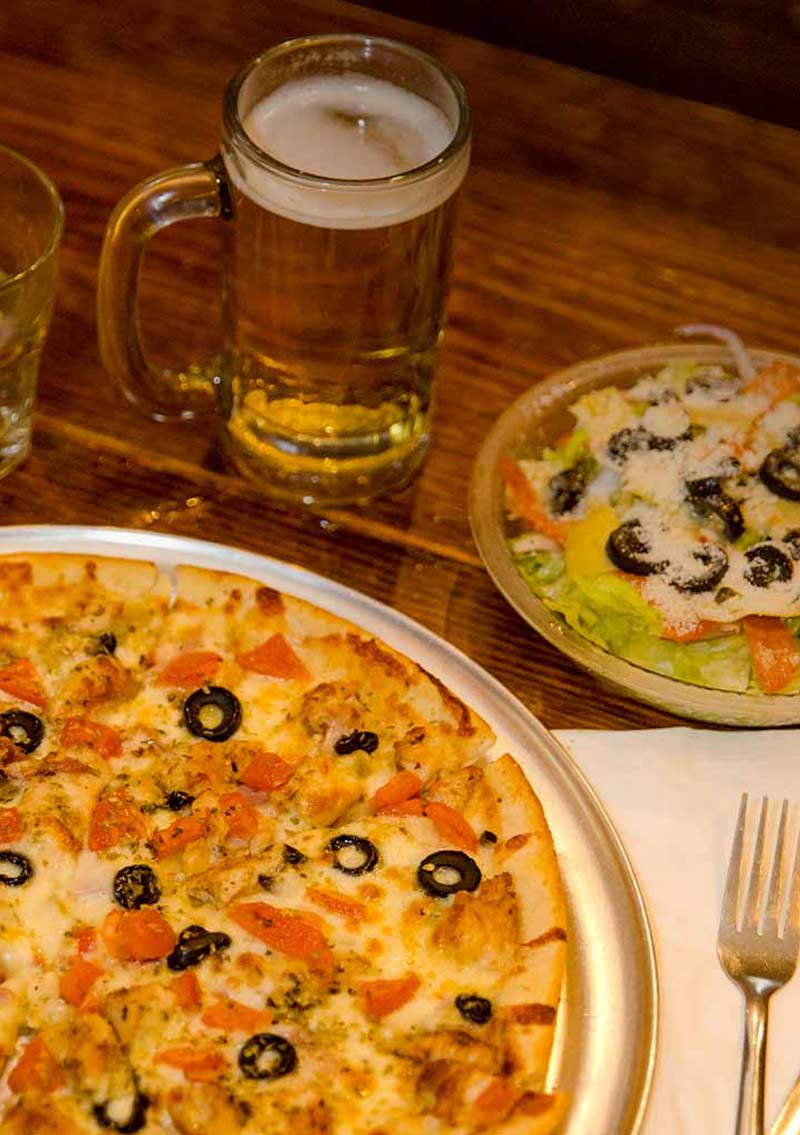 veggie pizza with beer and salad on wood table