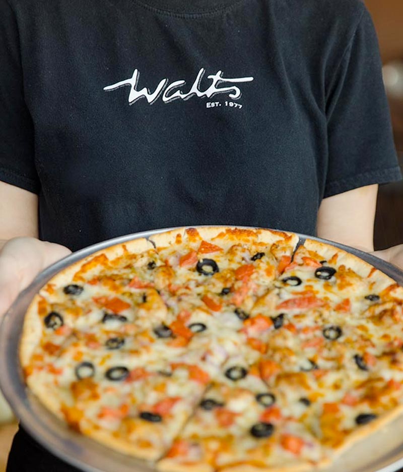 walts pizza server holding pizza