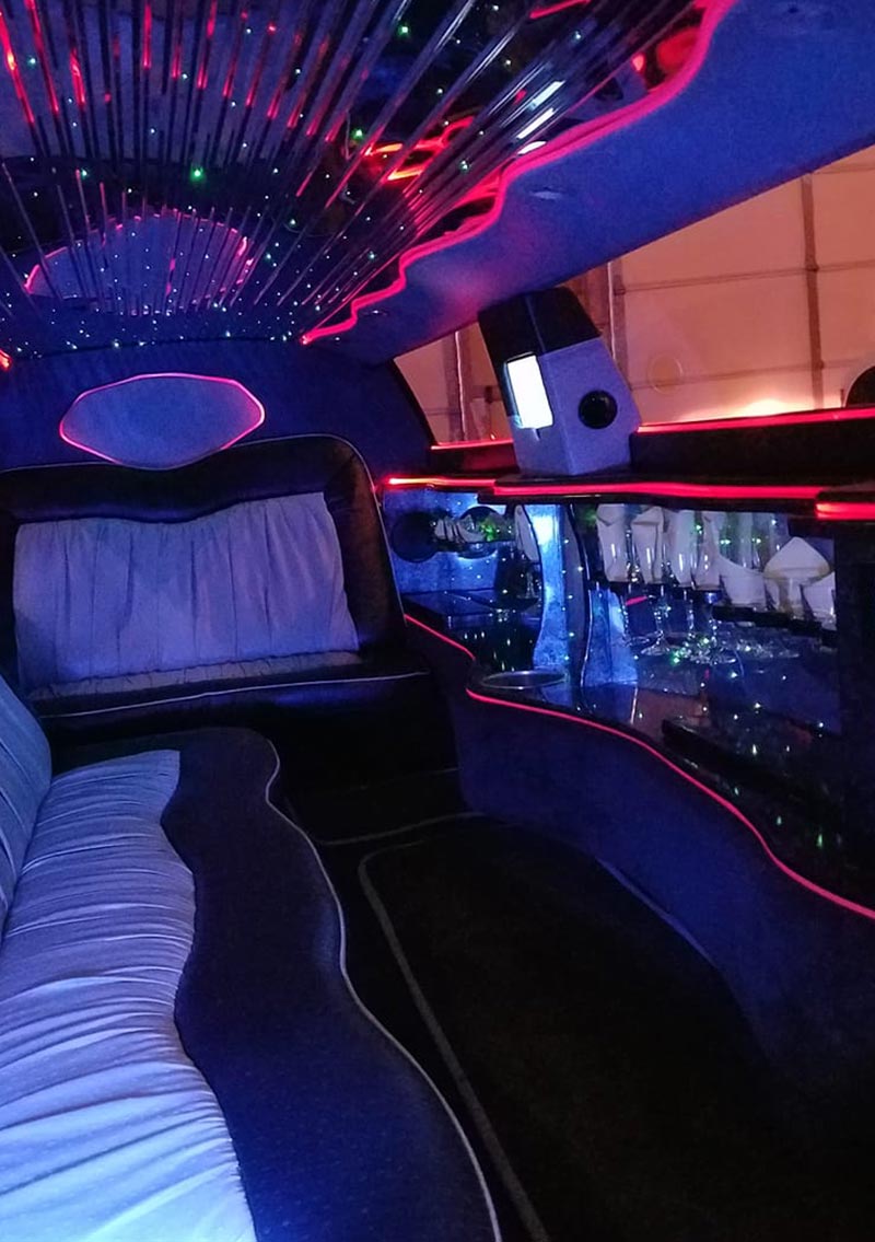 interior of limo with champagne glasses and colorful lights