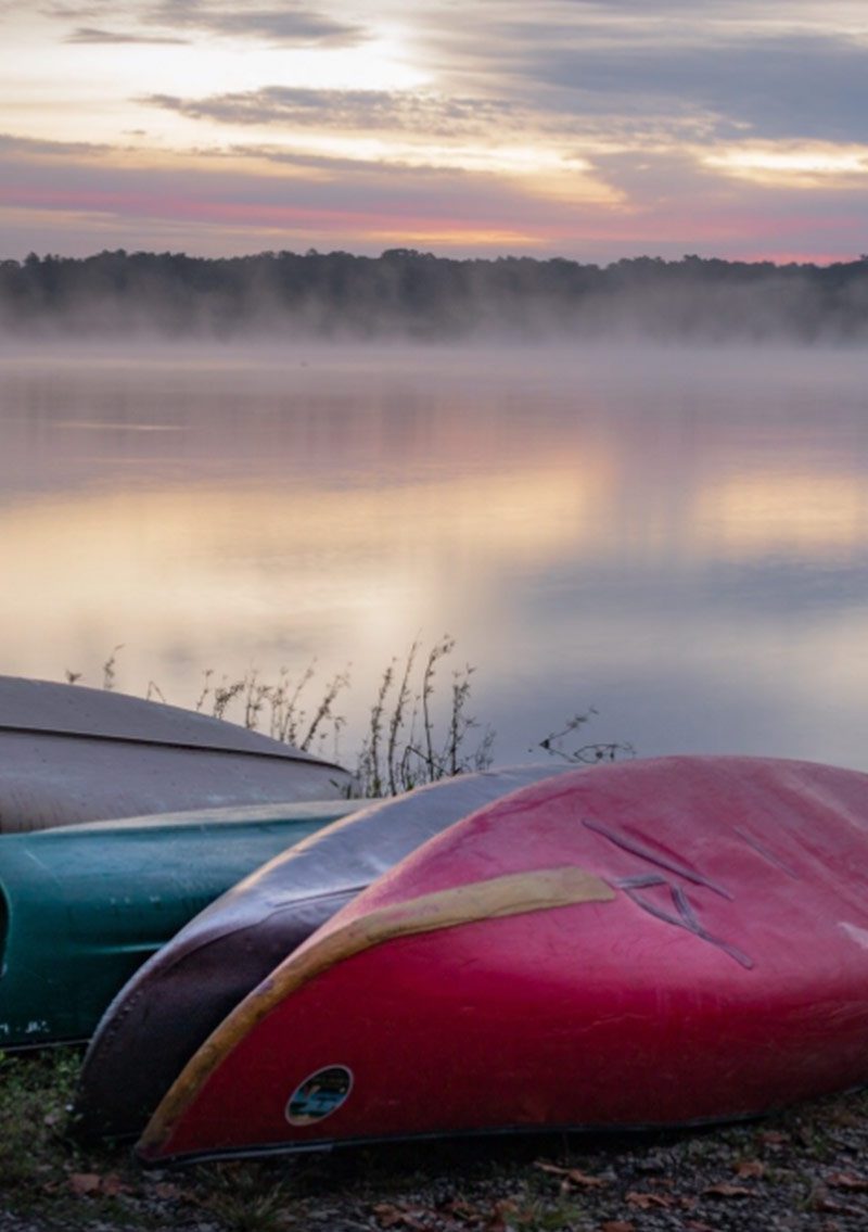 Morning fog over Little Grassy Lake with canoes on shoreline