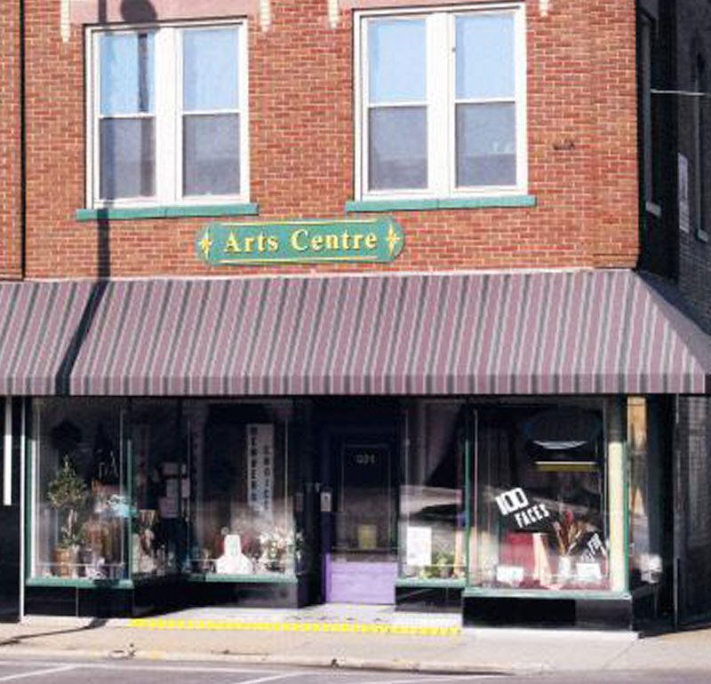 brick building with a red and maroon awning and a sign that reads arts centre