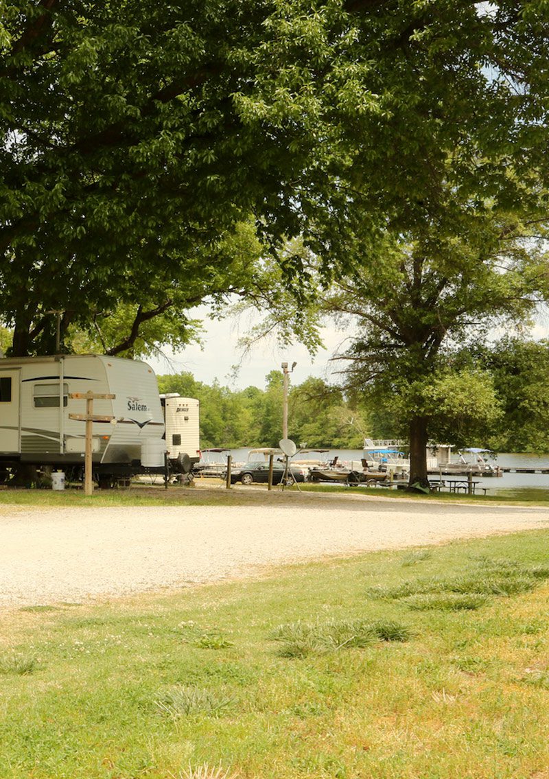 rvs parked in campground with lake in background