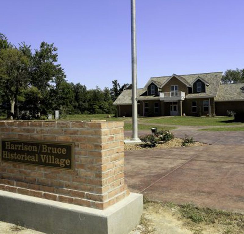 harrison bruce monument in front of historic village