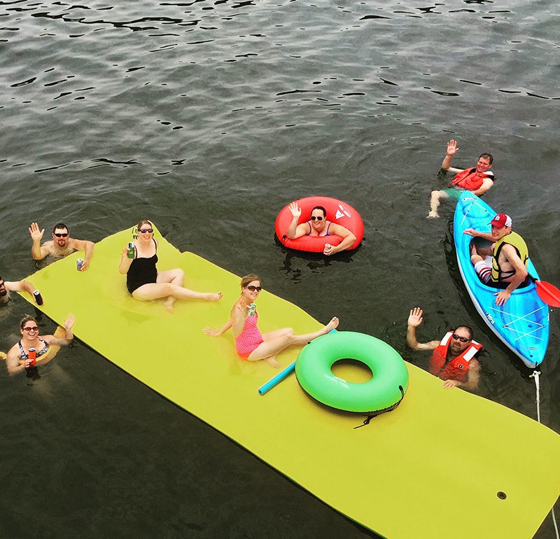 friends on rafts in lake