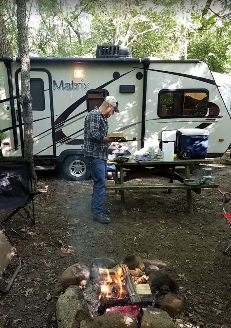 Man cooking by fire pit Marion Campground & RV Park
