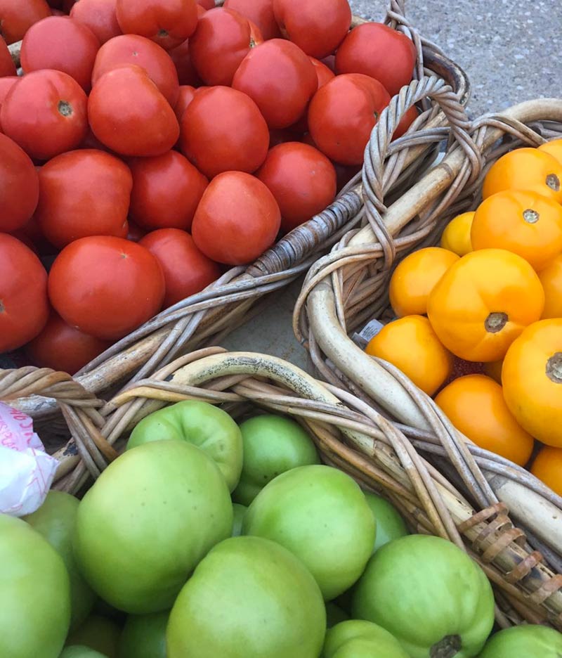 baskets of red, yellow and green tomatoes