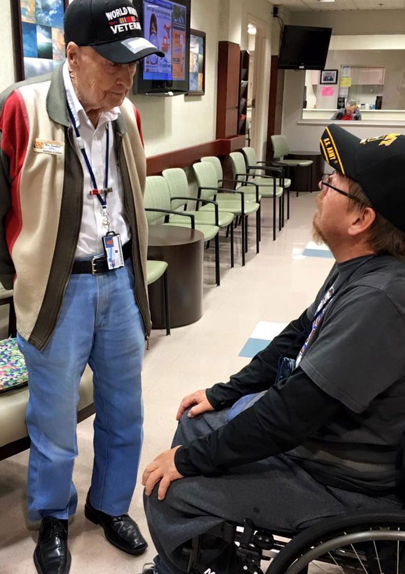 Older veteran talking to younger veteran in hospital