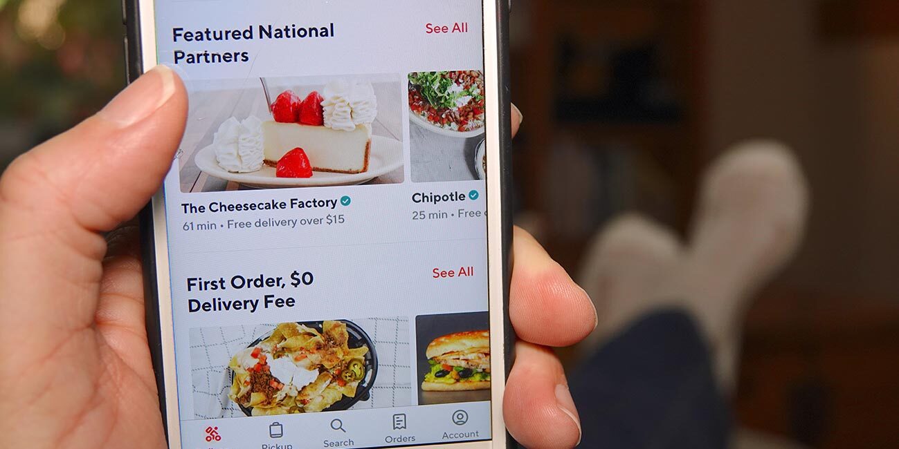 person with feet propped up using grubhub app