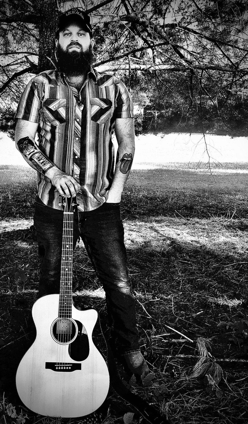 jonny-coller-with-guitar-in-front-of-tree-black-and-white-photo